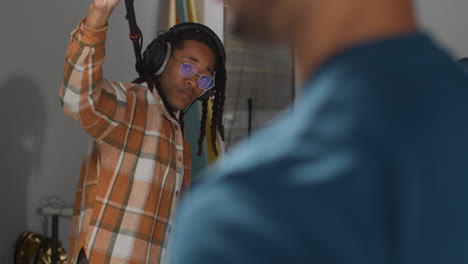 a man with headphones listens intently to a recording in a professional music studio.