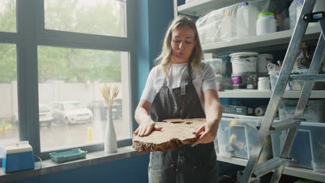 woman working with wood slice in her workshop