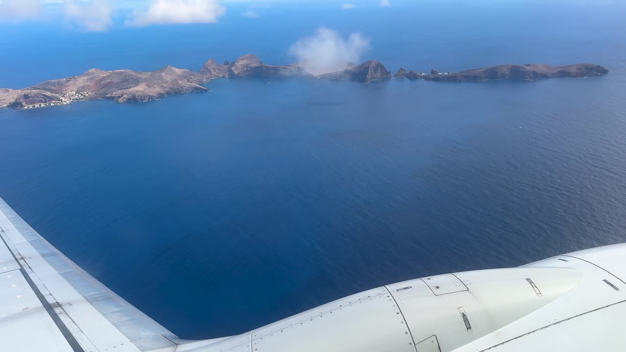 An airplane flies over a group of islands near Madeira, Portugal. View from the airplane window.