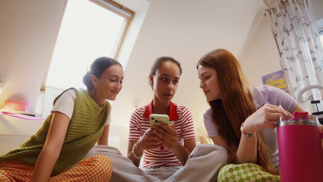 십대 소녀 들 이 스마트폰 을 보고 있다