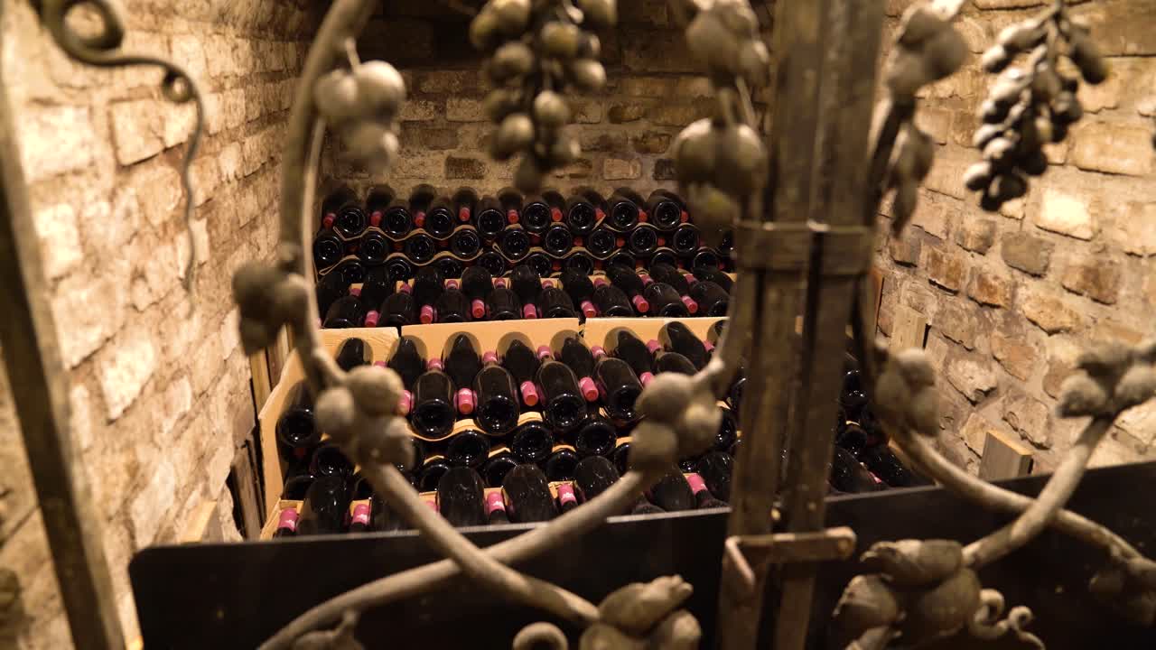 Gated wine cellar room filled with stored bottles in dolly out video