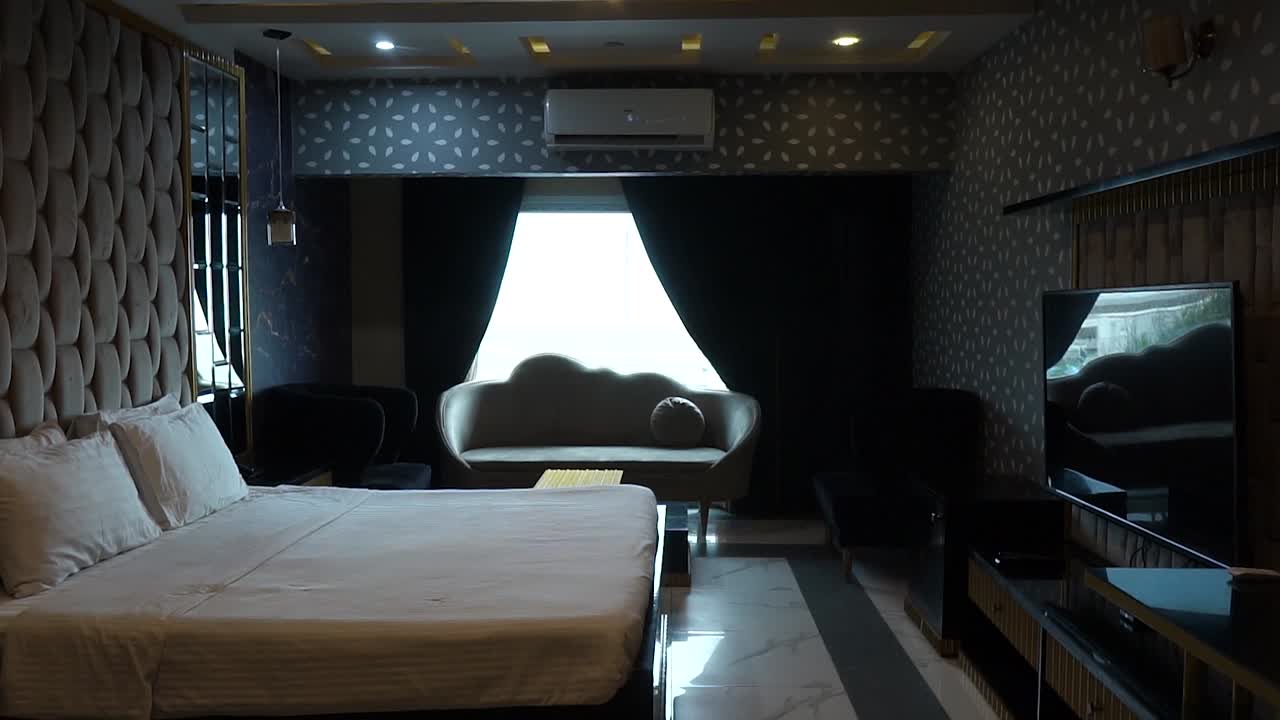 포브는 벽에 플래트 스크린을 매달고 현대적인 고급 침실에 걸어