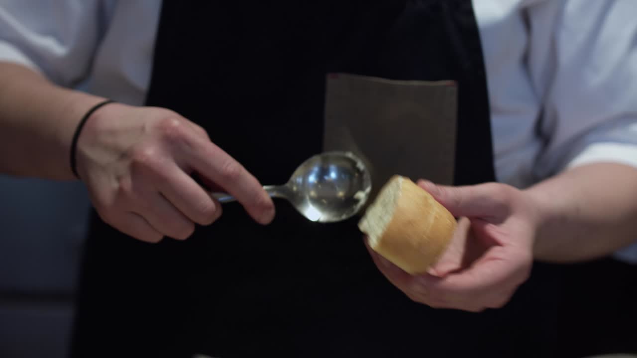 레스토랑 셰프가 빵의 평화에 버터를 바르고 있다