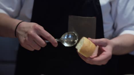 el chef del restaurante está untando mantequilla a la paz del pan