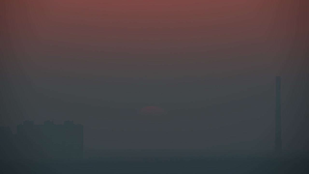 안개가 가득한 배경에서 아름다운 해가 지는 모습.