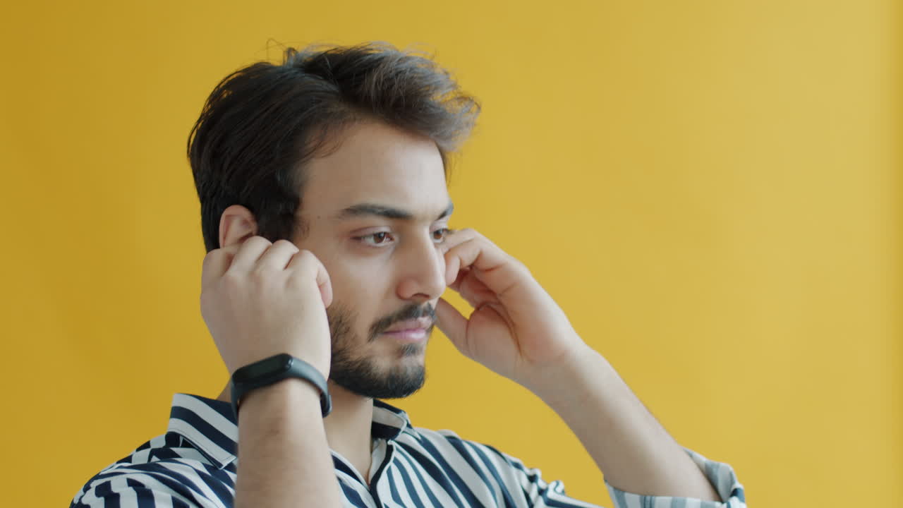Man wearing earbuds in profile view