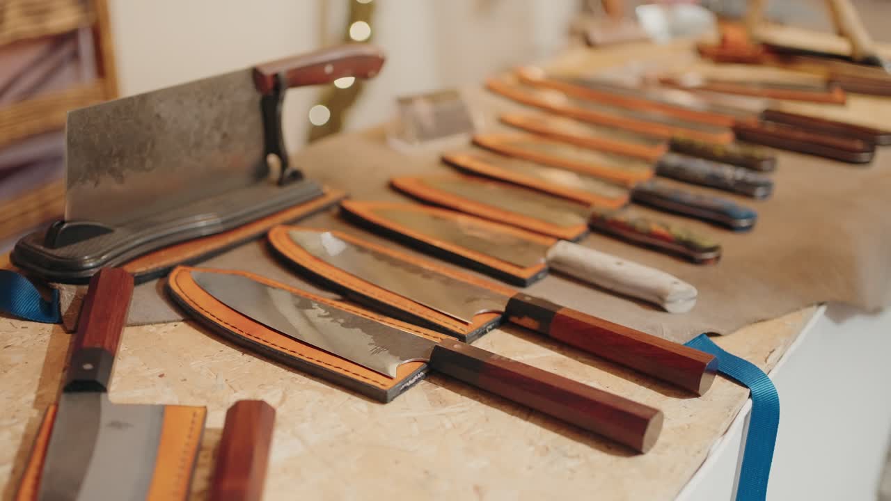 Handcrafted knives with wood handles and leather sheaths on a rustic display table