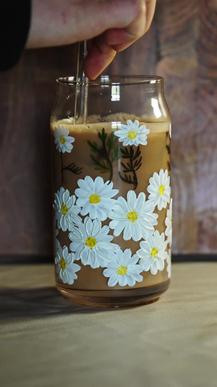 Caffè freddo presentato con tonalità naturali e un'ambientazione da tavolo moderna. Contenuto cinematografico di bevande adatto per temi di caffè, colazione o lifestyle.