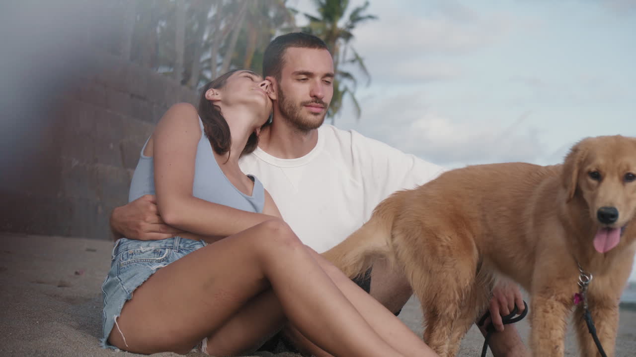 una pareja sentada en una playa de arena.
