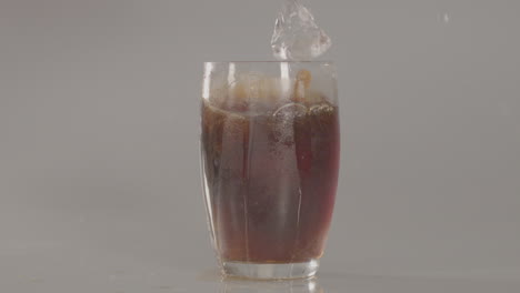 ice cubes falling into glass of cola in slow motion - 240 fps