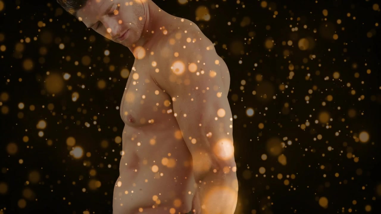 Modelo masculino cambiando el peso y girando a la izquierda, bokeh dorado flotando sobre el torso desnudo para la moda