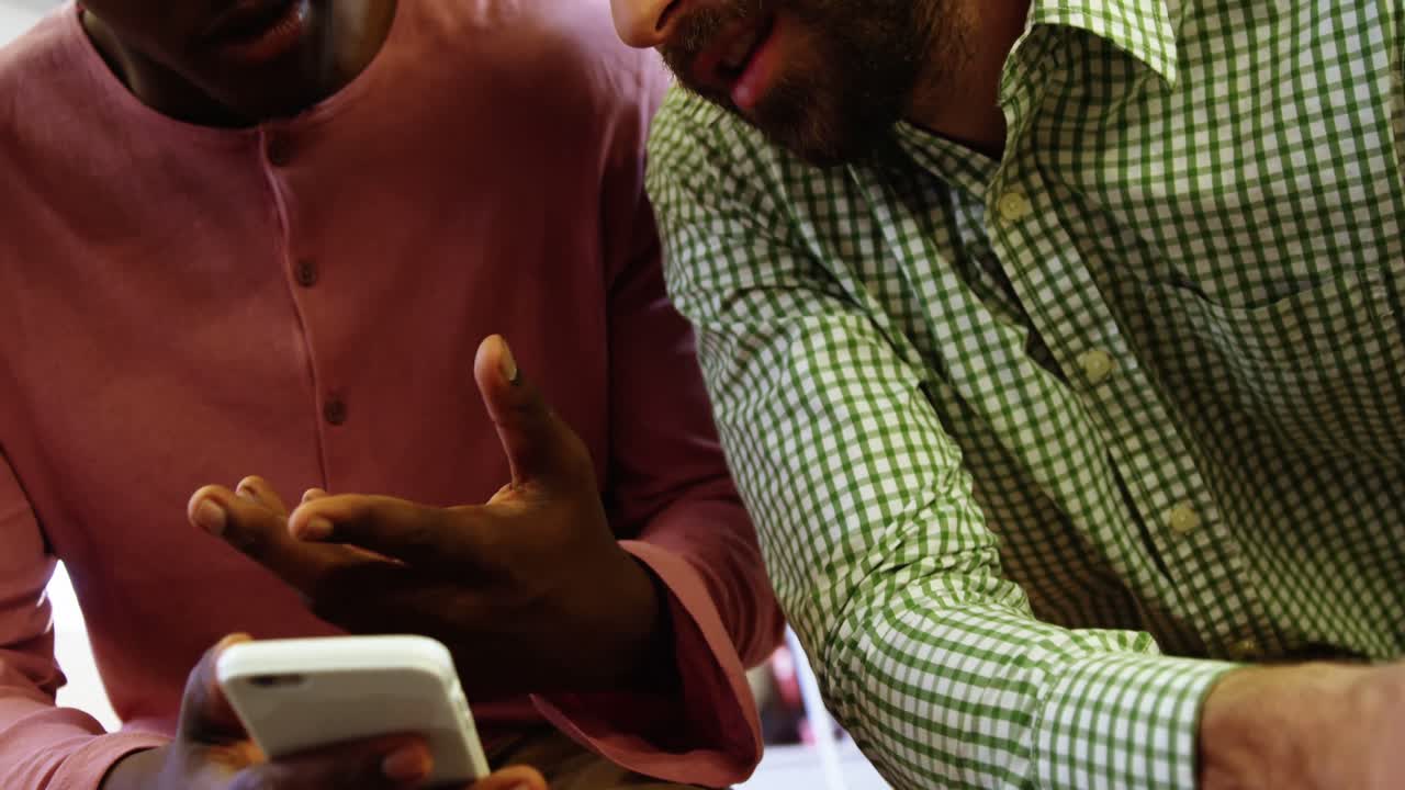 Business executives discussing over mobile phone