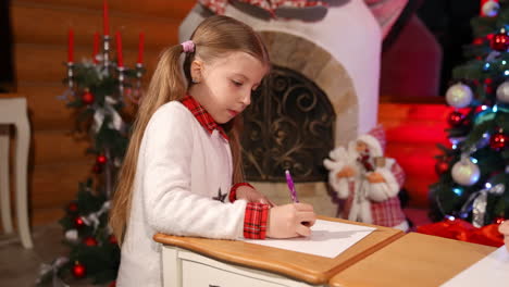 children painting at christmas decorated room. cute little girls sitting on floor and drawing pictures on small desks for santa. christmas spirit