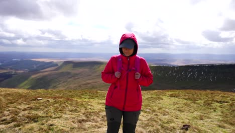 Woman-hikes-the-windy-trails-of-Pen-y-Fan-peak,-enjoying-the-mountainous-landscape-at-Brecon-Beacons,-Wales