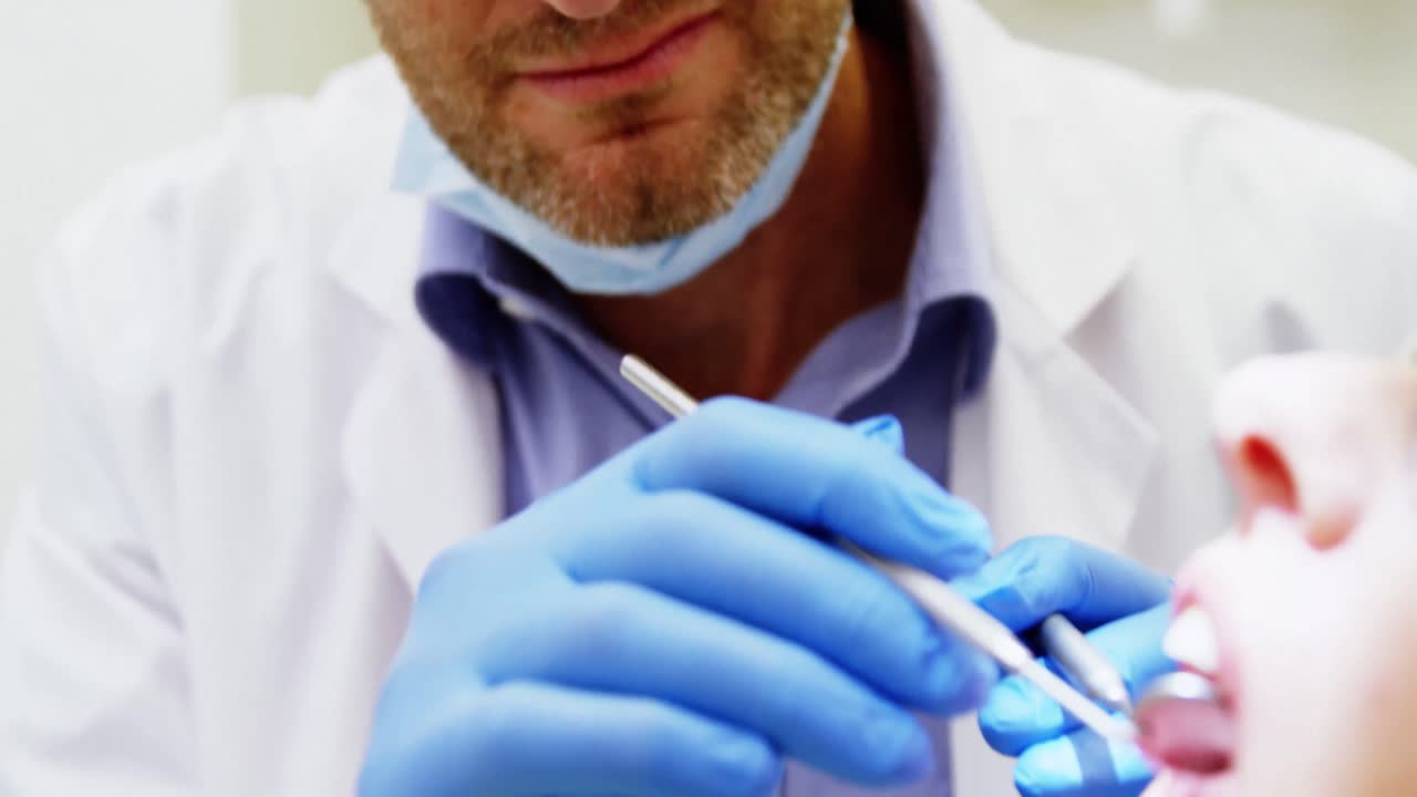 dentista examinando a una paciente con herramientas dentales