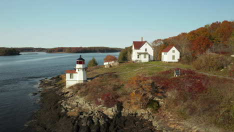 orbiting aerial shot of squirrel point lighthouse on scenic maine coast