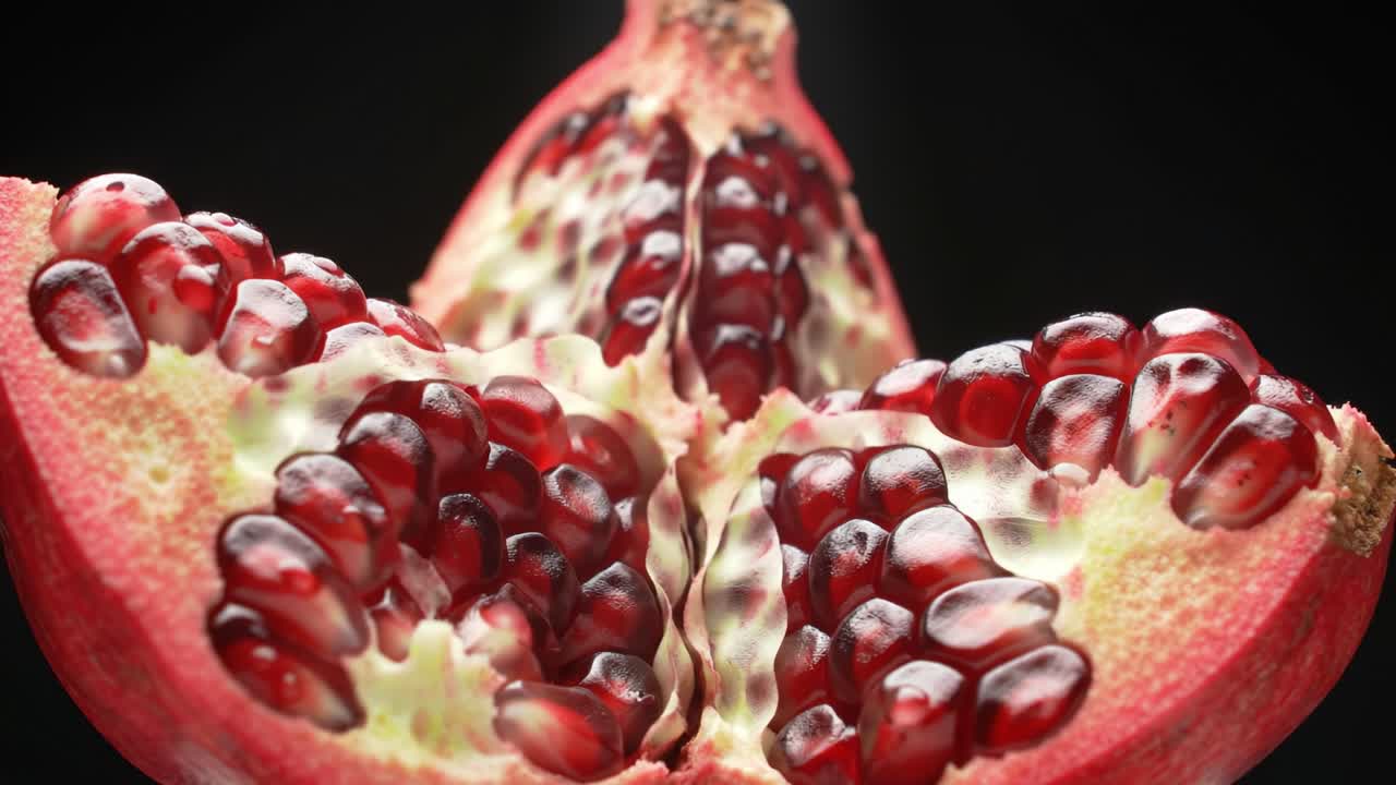A Close-Up View of a Pomegranate Fruit, Showcasing the Juicy Red Seeds and Vibrant Interior in Stunning Detail Against a Dark Background