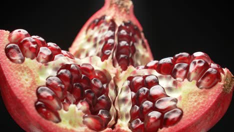 a close-up view of a pomegranate fruit, showcasing the juicy red seeds and vibrant interior in stunning detail against a dark background