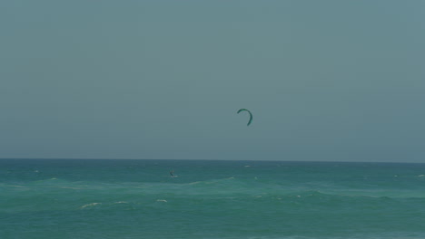 young man kite surfing in ocean, extreme summer sport slow motion in portugal