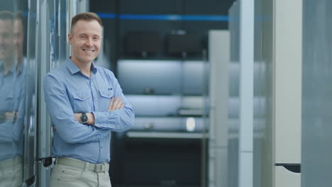 portrait of a professional expert consultant smiles and looks into camera as stands in the bright, modern electronics store full of latest models of tv sets, refrigerator, cameras, tablets and other devices.