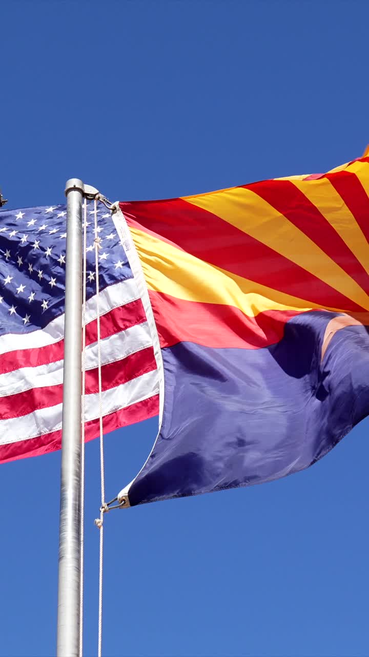 American and Arizona Flags Waving Against Blue Sky