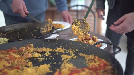 sirviendo paella a una reunión de personas que celebran