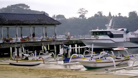 plano general del puerto de sanur lleno de botes mientras la gente trabaja y camina