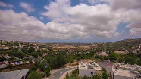 el lapso de tiempo de las nubes cúmulo barriendo los cielos azules sobre una pequeña ciudad en chipre