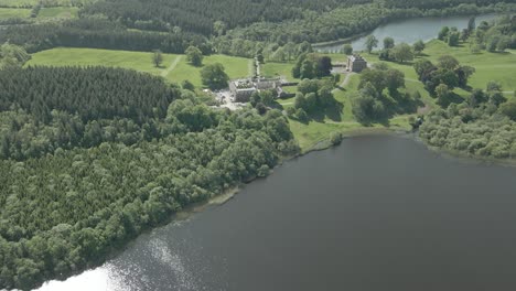 Vista-Aérea-Del-Castillo-De-Bellamount-Y-El-Bosque-Junto-Al-Lago-En-Verano-En-Cootehill,-Condado-De-Cavan,-Irlanda