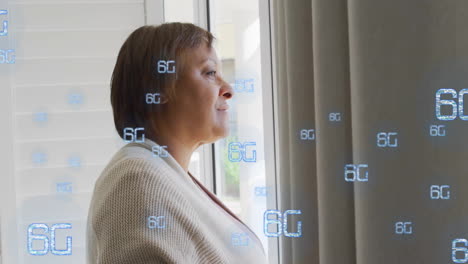 looking out window, woman with 6g technology animation overlay in background