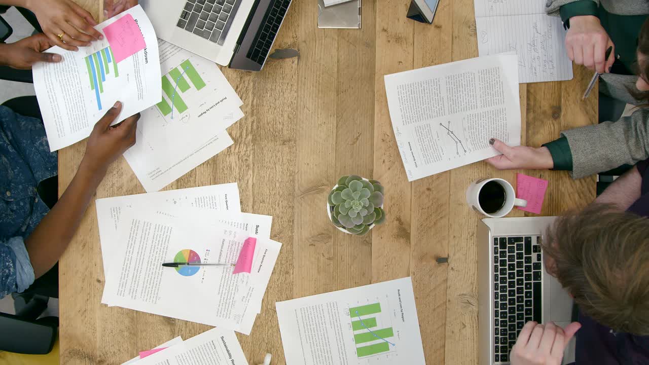 Overhead View Of Male And Female Colleagues Working Together At Desk