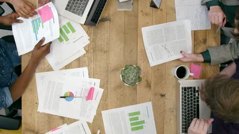 Overhead-View-Of-Male-And-Female-Colleagues-Working-Together-At-Desk