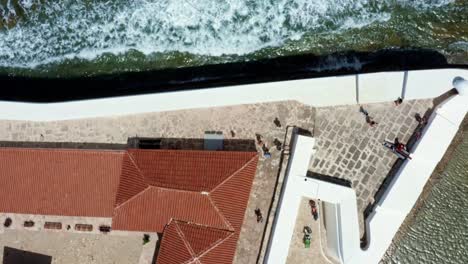 Rising-bird's-eye-top-aerial-drone-shot-revealing-the-historic-star-shaped-Reis-Magos-fort-with-waves-crashing-into-the-white-walls-in-the-beach-capital-city-of-Natal-in-Rio-Grande-do-Norte,-Brazil