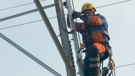 maintenance repair man climbs up high electrical pole