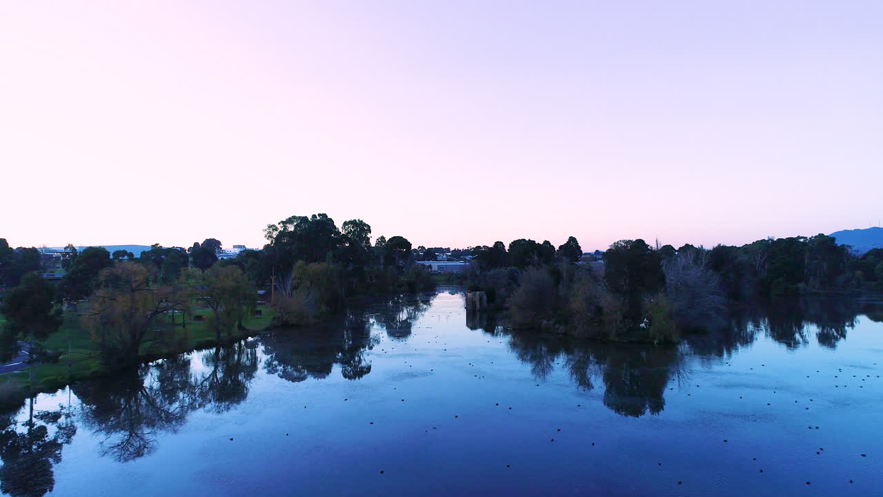 aspecto suave de drones volando sobre una gran masa de agua al atardecer