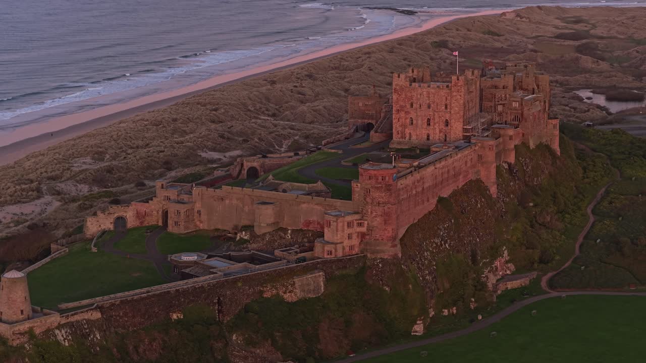 Luftfoto af Bamburgh Castle på Northumberland-kysten ved solopgang