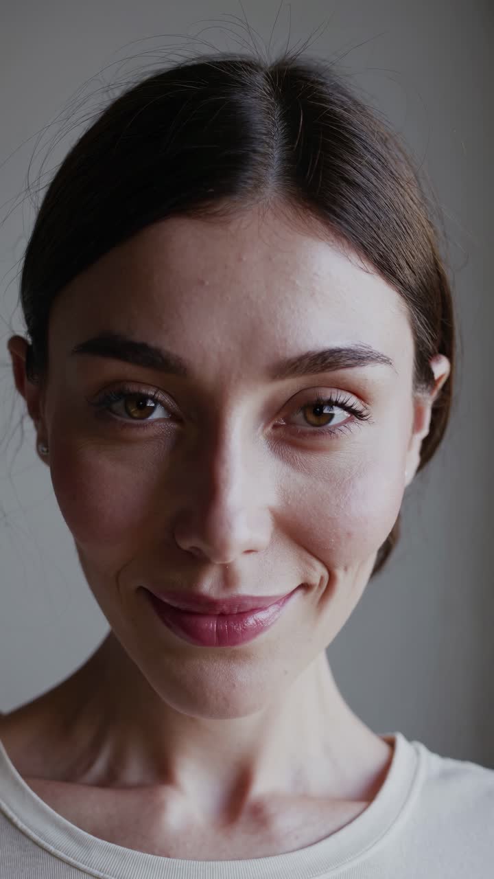 Primo piano di una donna sorridente con illuminazione naturale, ripresa da un angolo frontale