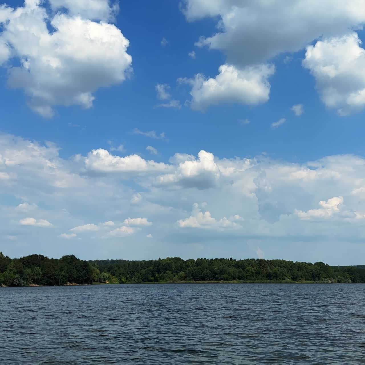 View of the river floating among the green banks. Wooden old bridge is near the waterfront