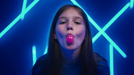 young girl blowing bubblegum in neon blue light