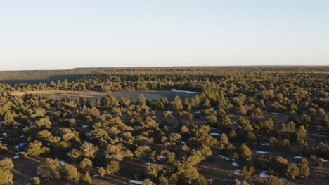 Aerial flight over coconino national Forest With Snow beside dry marshall lake in Arizona