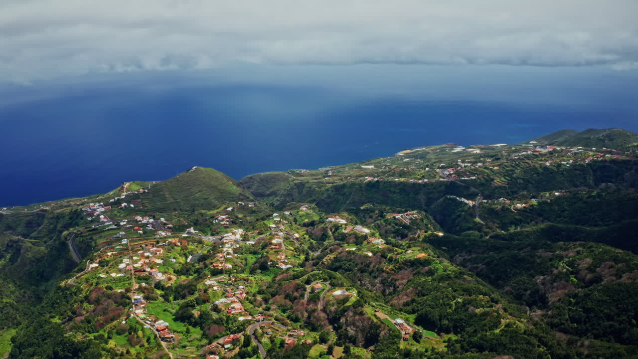 Aerial drone shot of the picturesque landscape in La Palma, Canary Islands. High view of the green lush vegetation, the coastline and the deep blue ocean.