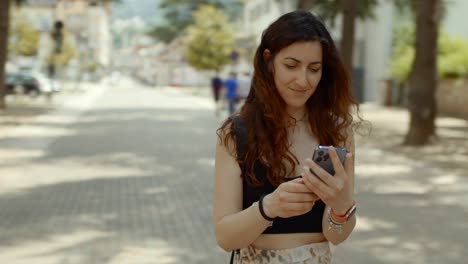 una mujer joven chequeando su teléfono después de recibir una notificación.