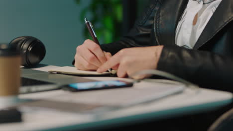 young business woman writing research notes brainstorming creative ideas for project working late in office using journal close up hands