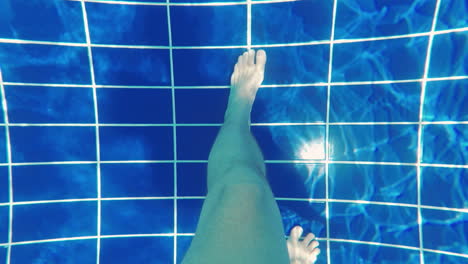 pies de hombres en el fondo de la piscina