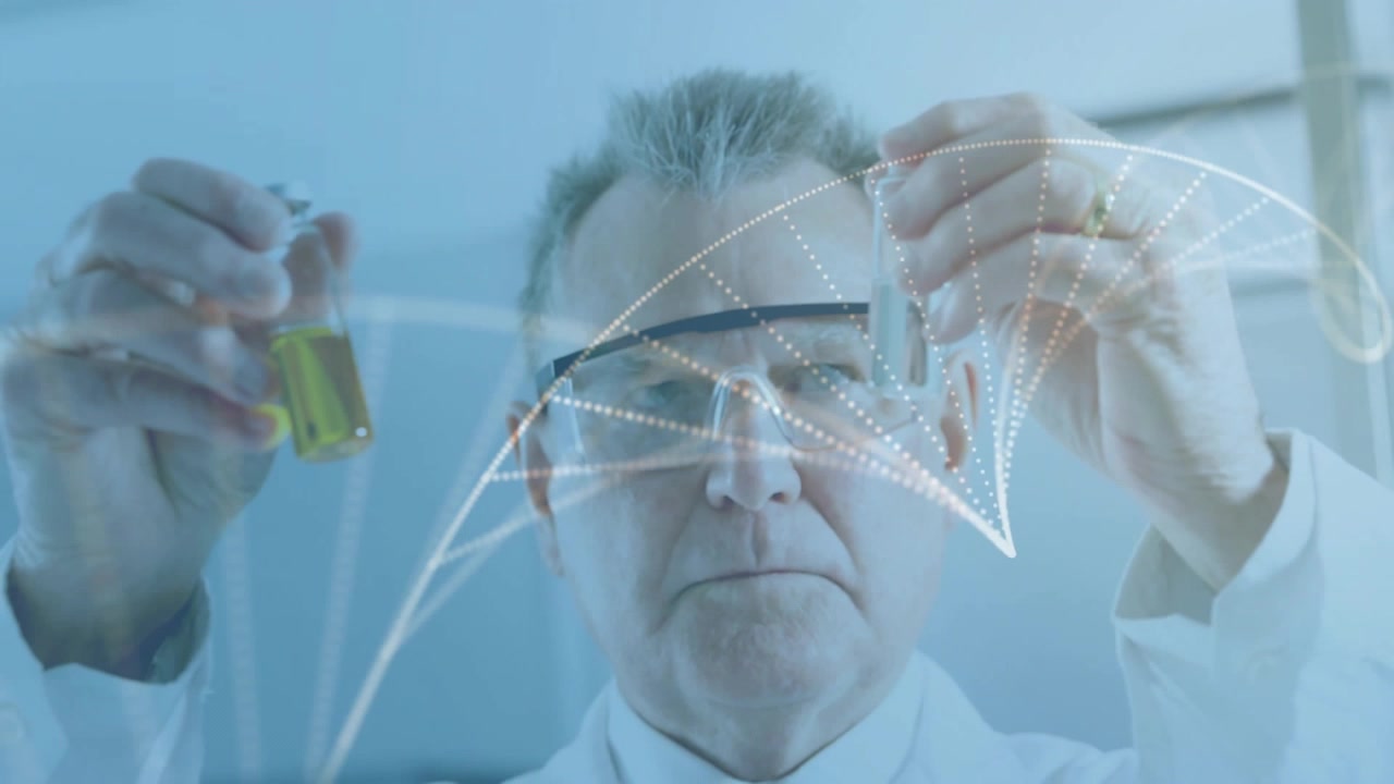Senior male scientist in lab coat and goggles inspecting yellow vial and test tube with overlay