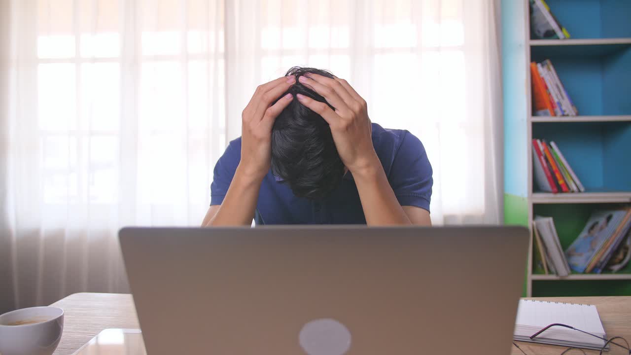 Stressed Young Man Working on Laptop