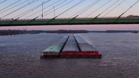 Imágenes-Aéreas-De-Drones-De-Una-Enorme-Barcaza-Que-Viajaba-Bajo-Un-Puente-De-La-Autopista-En-El-Río-Mississippi-Cerca-De-Burlington,-Iowa