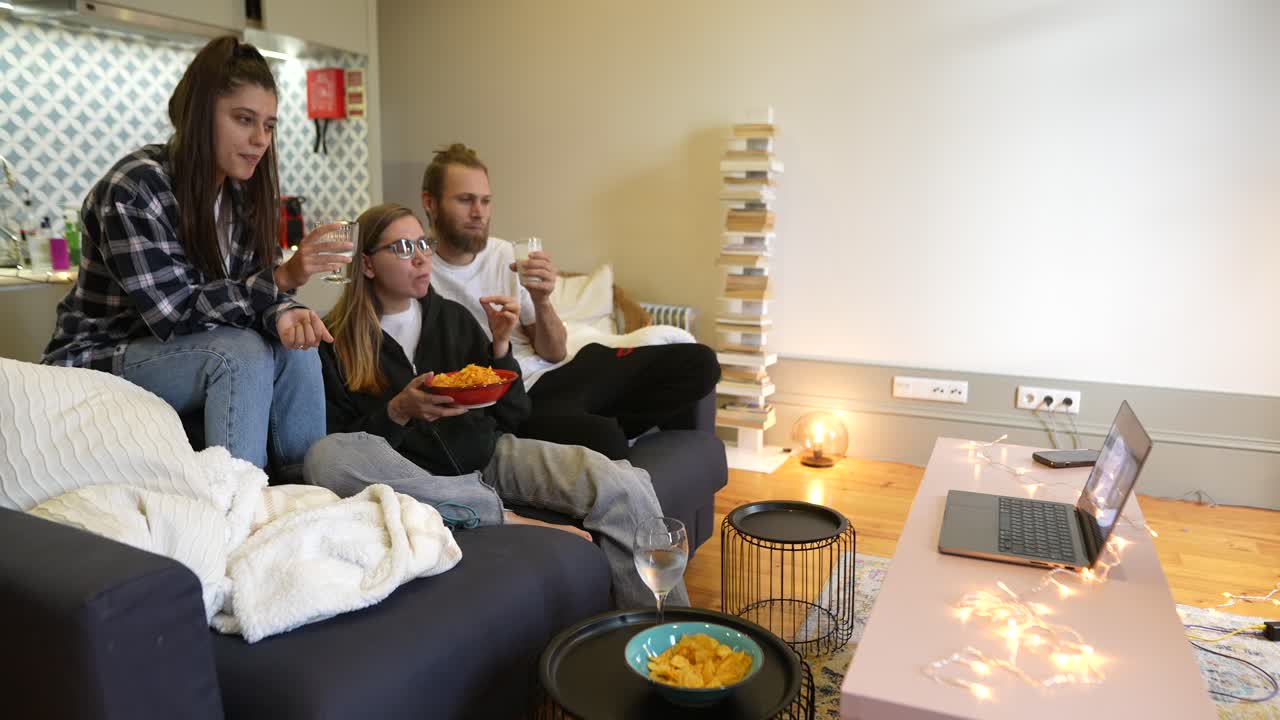 친구들이 집에서 영화나 tv 쇼를 보고 있습니다.