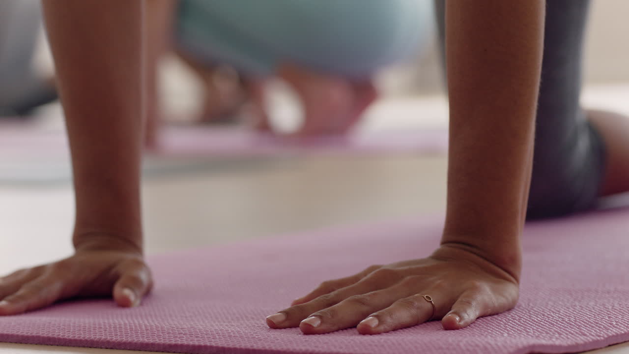 cerrar las manos de una mujer de yoga estirando la postura de los niños practicando en una colchoneta de ejercicios disfrutando de un entrenamiento de estilo de vida saludable en un estudio de bienestar