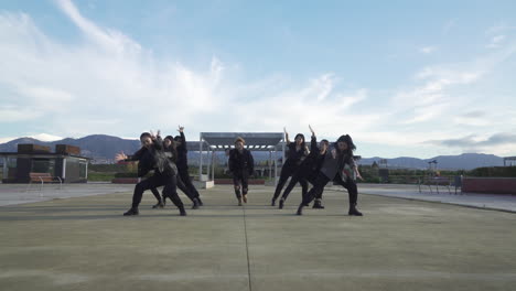 young street performer performing on the street. seven chinese teenagers dancing kpop